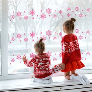 Pink glitter snowflake window stickers shown with children in a cozy festive home setting