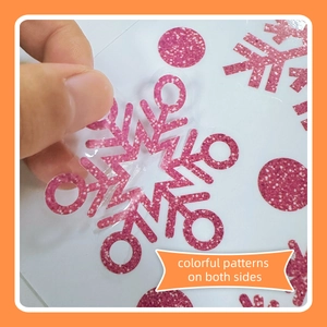 Close-up of pink glitter snowflake window sticker with colorful patterns on both sides