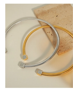 Detail of C-shaped choker necklaces in gold and silver finish with sparkling rhinestone ends