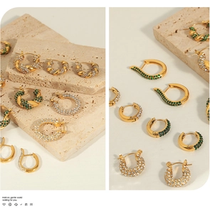 Détails de boucles d'oreilles torsadées dorées et créoles en zircon sur travertin