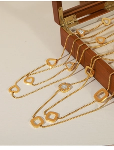 Detail einer goldenen Box-Halskette mit Herzanhänger und quadratischem Kristall
