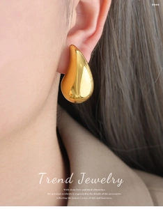 Close-up of chunky gold water drop earrings in 18K plated stainless steel on model