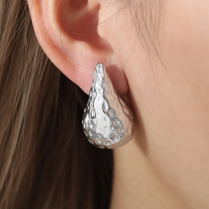 Waterdrop stud earring with hammered silver texture finish on elegant model profile