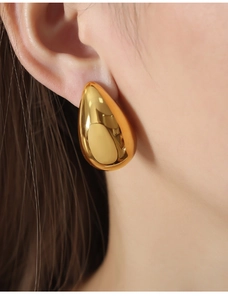 Close-up of 18K gold plated teardrop earrings showing high-shine mirror finish on model