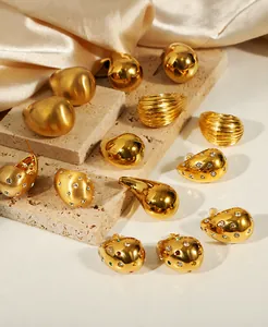 Detail view of various 18K gold plated teardrop earrings on elegant stone and silk