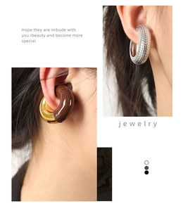 Detail of 18K gold plated earrings with textured metallic finish and enamel inlay