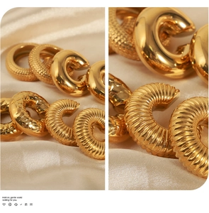 Macro detail of 18K gold-plated C-shaped earrings with hammered and threaded textures