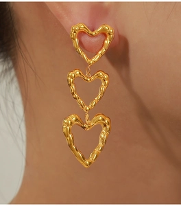 Detail shot of vintage hollow gold-plated heart earrings with irregular wavy texture