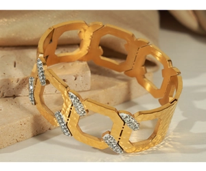 Close-up of gold geometric hollow cuff with hammered texture and zircon inlays