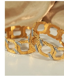 Detail of gold geometric C-shaped bangle with cubic zirconia pavé and hammered texture