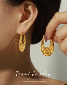 Detailed view of layered gold-plated teardrop earrings with a polished metallic texture