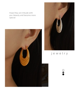 Detailed macro view of gold and silver plated crescent hoop earrings with ripple texture