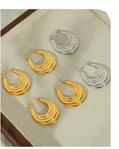 Macro view of multi-layered crescent hoop earrings in polished gold and silver finishes