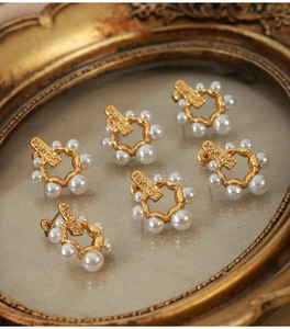 Gros plan de boucles d'oreilles dorées vintage avec perles sur cadre en métal martelé