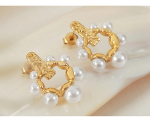 Détail de boucles d'oreilles dorées avec perles dégradées et texture martelée style vintage