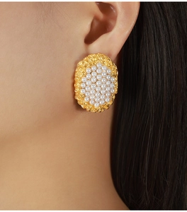 Detailed close-up of large golden French vintage oval stud earrings with white pearls