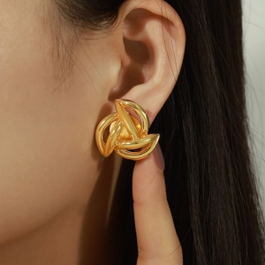 Elegant 18k gold plated hollow knot earrings worn on model for a chic French style look
