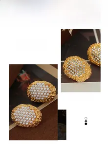 Close-up of vintage oval button earrings with faux pearls and sparkling rhinestones