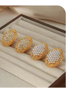 Detailed shot of oval gold button earrings with pavé rhinestones and vintage pearls