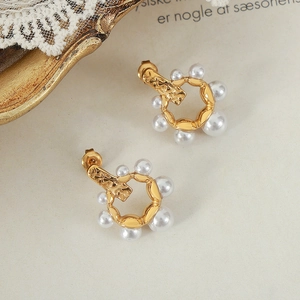 Boucles d'oreilles créoles perles vintage dorées sur fond rétro élégant