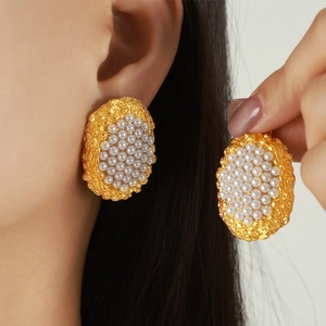 French style oval gold lava textured stud earrings with white pearls on female model