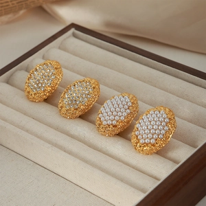 Irregular geometric titanium earrings with inlaid zircons and pearls in a gold finish