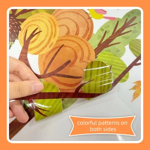 Close-up of double-sided autumn forest window stickers with trees and birds motifs