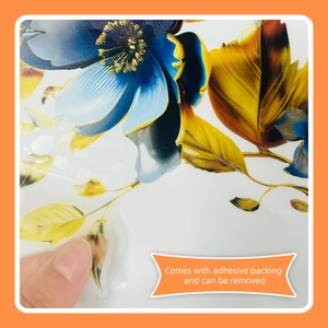 Detail showing the self-adhesive backing of blue floral wall stickers being removed
