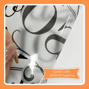Detail of self-adhesive bathroom wall sticker with floral script and back adhesive