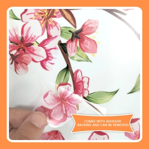 Detail showing self-adhesive backing being removed from floral peach tree wall sticker