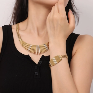 Détail du collier et bracelet dorés de style clôture avec incrustations de zircons
