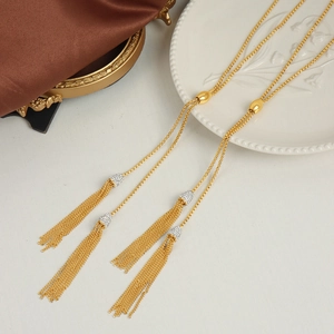 Lange gouden kwastjesketting met zirkonia en verstelbare kraal op satijnen decor