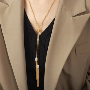 Elegante lange gouden kwastjesketting met zirkonia accenten op een kaki blazer outfit