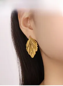 Detail shot of gold leaf earrings showing intricate radial veins and textured edges