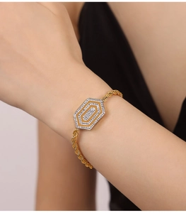 Nahaufnahme eines goldenen Zirkonia-Armbands mit Seilkette am Handgelenk einer Frau