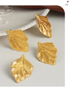 Detail of gold leaf earrings showing intricate radial texture and metallic finish