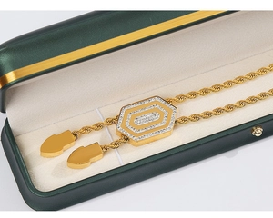 Nahaufnahme eines goldenen Oktogon-Zirkonia-Anhängers mit Mesh-Kette in einer grünen Box