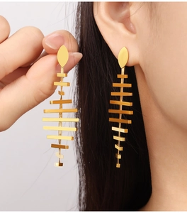 Close-up of elegant gold tassel drop earrings with a geometric fishbone fringe design