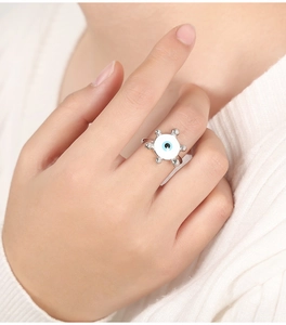 Makroaufnahme eines verstellbaren Rings mit Evil Eye-Motiv und weißer Emaille