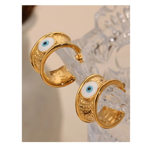 Detail von goldenen Hammer-Creolen mit Evil-Eye-Emaille-Anhängern am Glasrand