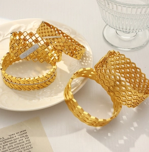 Detalle de cuatro brazaletes geométricos calados bañados en oro de 18k con cristales
