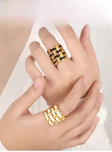 Macro detail of wide braided lattice ring with black and white enamel in 18k gold plating