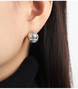 Vue macro d'une boucle d'oreille boule en acier poli de 10mm portée par un mannequin