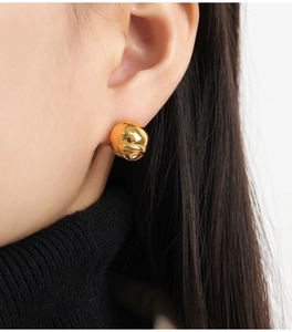 Gros plan de boucles d'oreilles rose dorées avec cristal sur le lobe de l'oreille