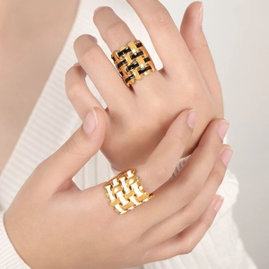 Modern 18k gold plated woven rings with black and white enamel inlays on hand