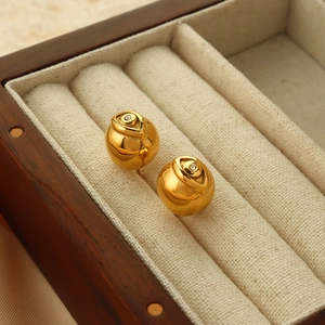 Boucles d'oreilles œil de démon roses dorées avec diamants sur doublure de boîte à bijoux