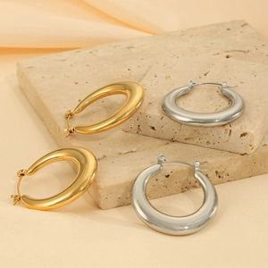 Boucles d'oreilles créoles polies en or et argent sur pierres décoratives