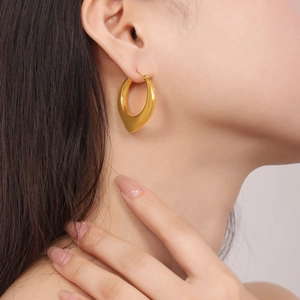 Boucles d'oreilles géométriques en U en acier inoxydable doré sur un modèle