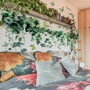 3D ivy leaf wall stickers with butterfly decals and floral bedding in a cozy bedroom