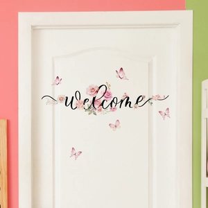 Detail of floral welcome door sticker with pink roses and butterflies on white door